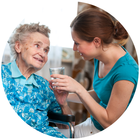 caregiver assisting an old woman to drink water